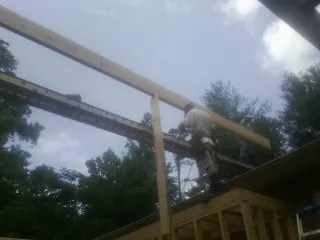 Carpenter setting a ridge beam over a new addition frame — Ice Dam Removal by Roofing Brothers in Enid