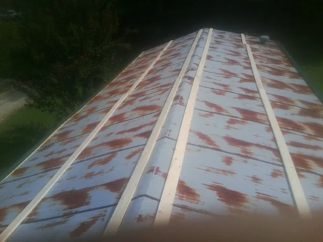 Rusted metal roof panels with new wood purlins before replacement — Storm Damage Roof Repair in Enid by Roofing Brothers