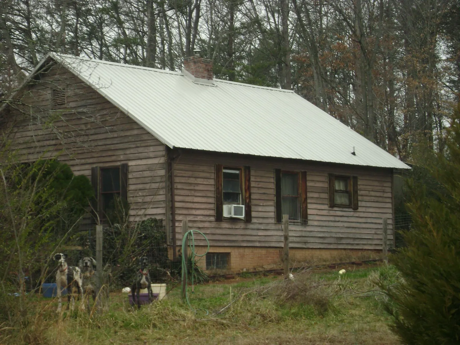 White metal roof on an old wood sided farmhouse, from a Metal Roof Installation job in Enid